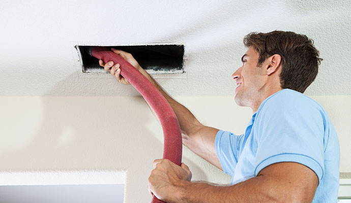 Expert performing professional air duct cleaning